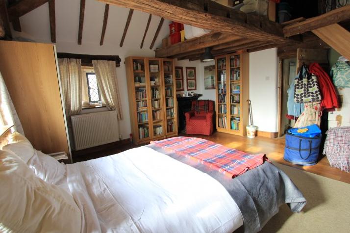 An impressive room which includes revealed ceiling timbers and an open loft with stair access to a mezzanine platform. The bedroom has an oak floor and two windows allowing pleasing views across the neighbouring countryside. The room also includes two built-in wardrobes and a cast iron fireplace.