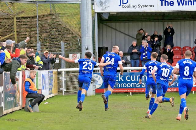 Tom Denton celebrates with his teammates in front of the Chesterfield fans after scoring his penalty. He's scored four goals in his last five games.