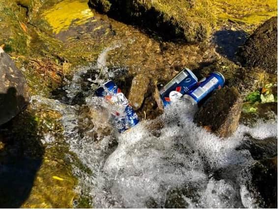 Beer cans dumped in a river in the Peak District.