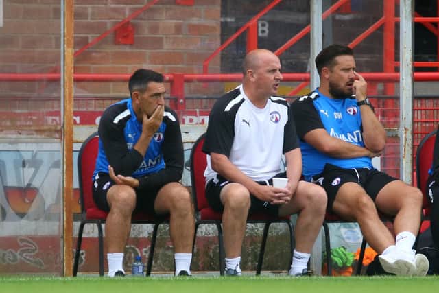 Gary Roberts, Paul Cook and Danny Webb in the dugout at Altrincham.