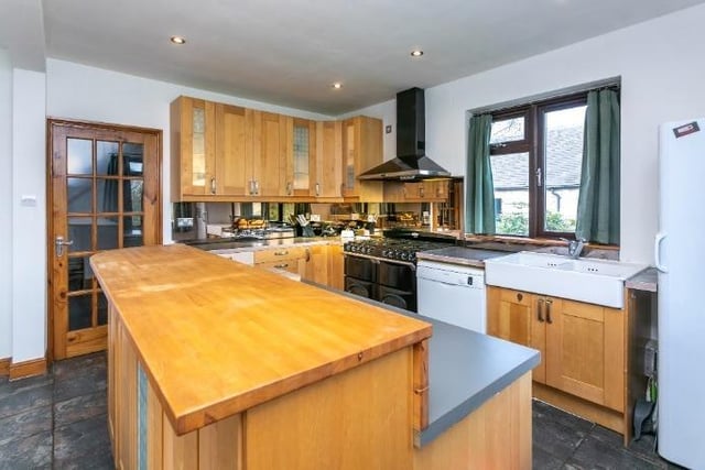 The kitchen is fitted with wooden storage cupboards at floor and eye level.