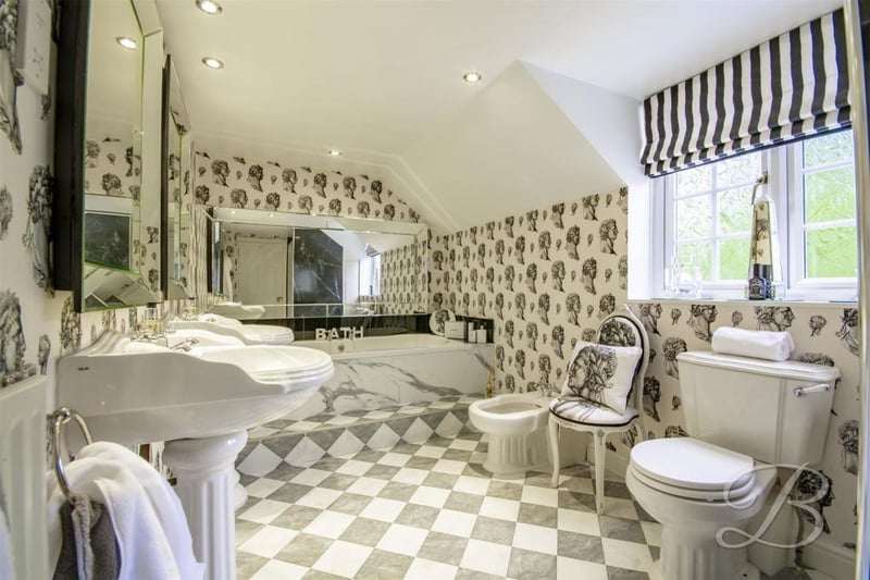 A family bathroom, probably best described as spectacular. It boasts an enclosed shower, bath, two pedestal sinks, central heating, low-flush WC, bidet and opaque window to the side.
