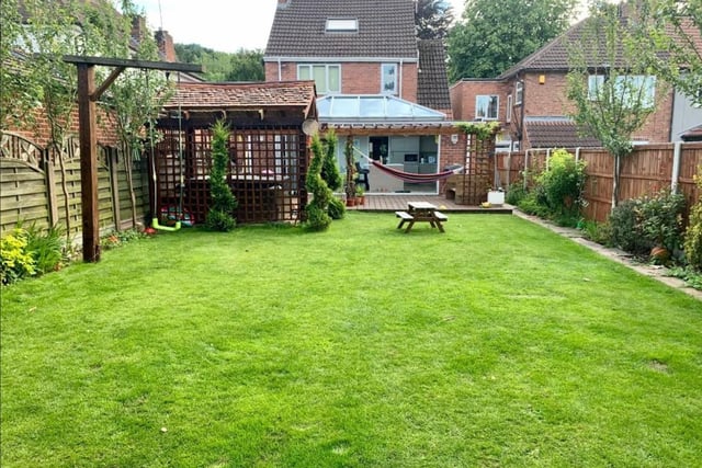 The large garden has a lawn and deck area.