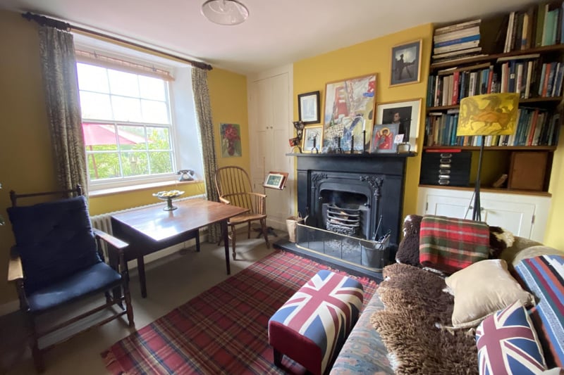 The cosy sitting room includes a feature cast iron fire, built-in storage and bookcase.