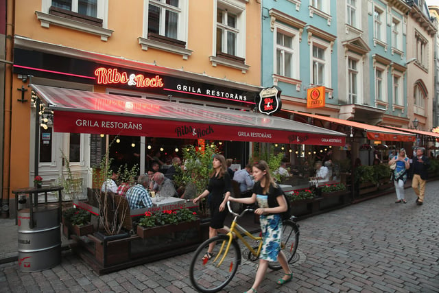 People are pictured walking past bars and restaurants in the old city centre in Riga. Flights go to Riga from Doncaster Sheffield Airport.