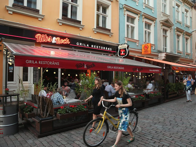 People are pictured walking past bars and restaurants in the old city centre in Riga. Flights go to Riga from Doncaster Sheffield Airport.