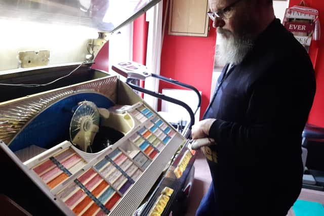 Stan selects a record on his jukebox.