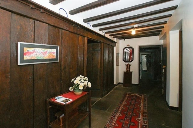 An early panelled wall with later fitted delft rack, stone flag floor and exposed oak beams are features of the reception hallway. There is an original broad oak batten door with thumb latch which opens to the dining room.