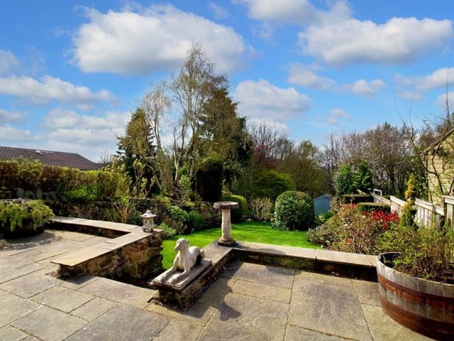 Steps lead down from the patio at the rear of the house to a large expanse of lawn.