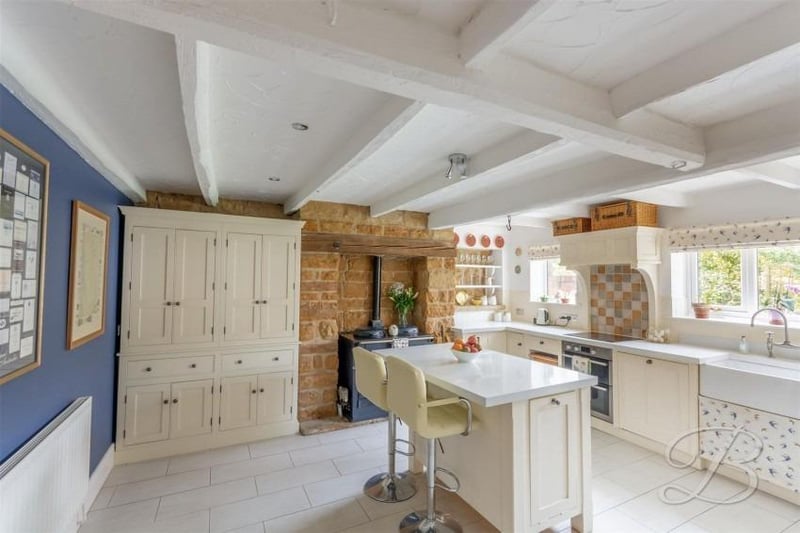 Into the kitchen now, where a characterful room comes complete with a range of traditional units and cabinets, plus a complementary work surface and Belfast sink. There are also built-in cupboards and a central island with breakfast bar.