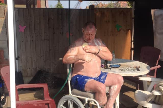 Tony Rawson pictured showering outside when he was forced to wash under a gazebo