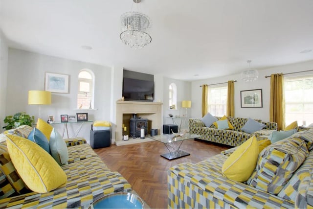 The main reception room has two triple glazed sash style windows to the front, multi fuel stove set in a Minton style fireplace with a matching hearth and media wall above with cabling for a TV.