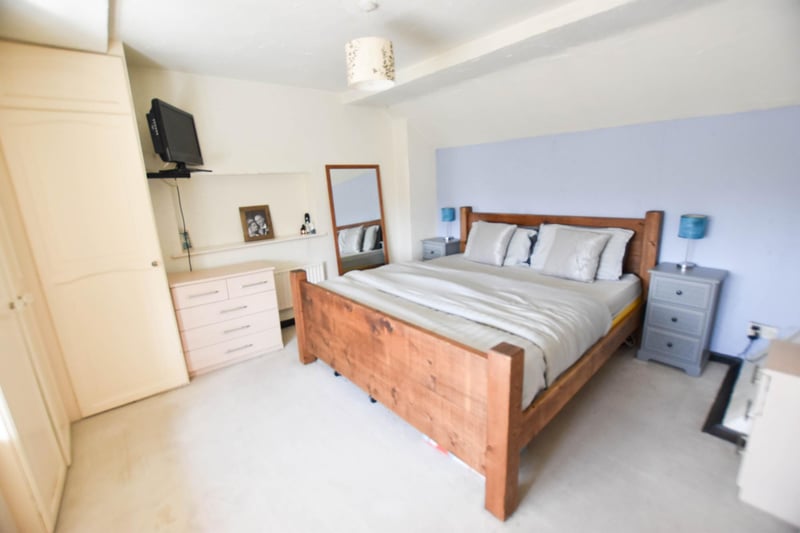 A bright and spacious double bedroom with neutral decor, carpet flooring and built-in wardrobes.