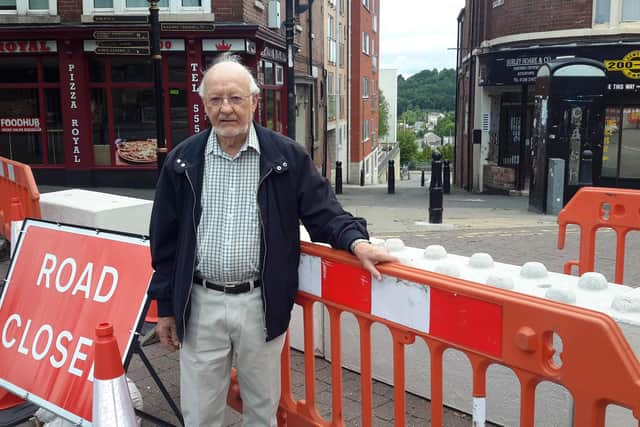Liberal Democrat Councillor Keith Falconer at the closed road signs on Corporation Street in Chesterfield.