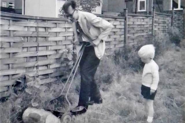 David Holliday mows the grass at his home in Hady, watched by his son Simon in the late Sixties.