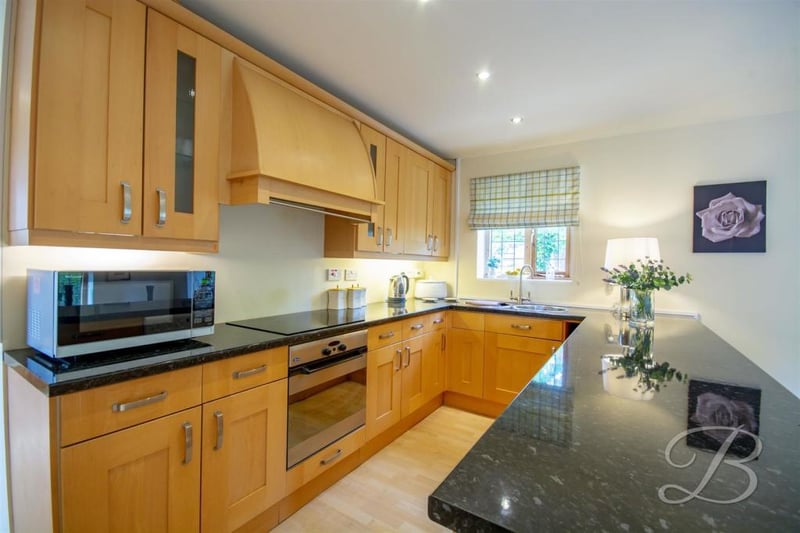 The kitchen inside the annexe. It includes shaker-style cabinets and units, a work surface, integral dishwasher and an inset sink with a mixer tap above.