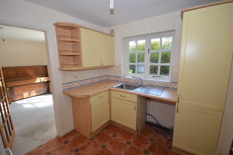 The utility room has fitted wall and base units with a sink integrated into the worktop.