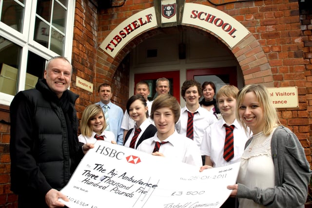 Tibshelf School gave a £3500 cheque to Derbyshire, Leicestershire and Rutland Air Ambulance, proceeds of a bike ride  in honour of a former teaching assistant whose life was saved by the service. Adrian Pearson, the former teaching assistant,, and Gemma Hinds, far right, from the air ambulance are pictured with pupils and school staff.