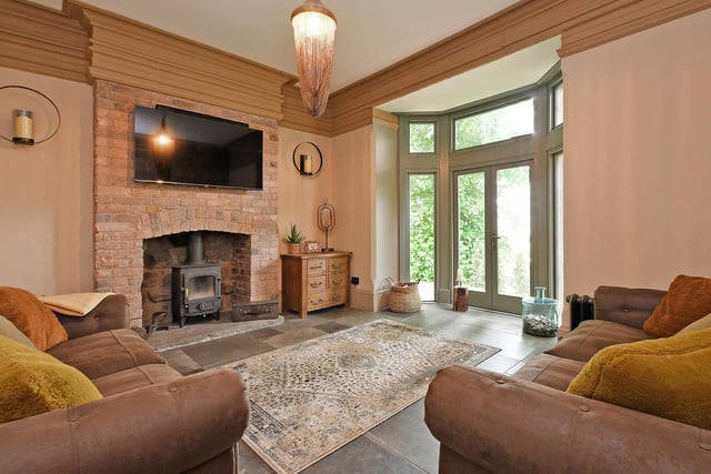 Deep wooden coving,  a feature fireplace and French doors in the bay window area give this room the wow factor.