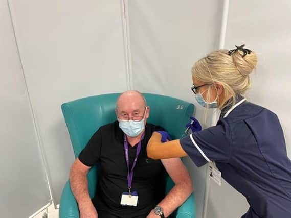 Covid vaccinations. Michael Burnell who works supporting the Sheffield Hospitals Pharmacy team aged 81, having his vaccination from Sister Amber Mills.