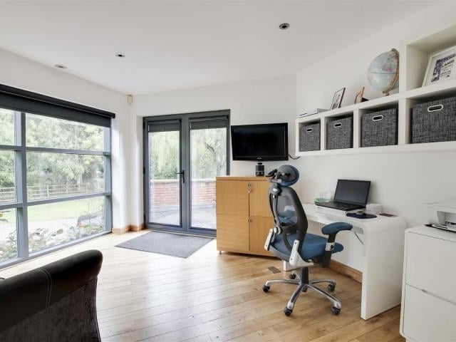 This reception room, which is currently being used as an office, has wood flooring with underfloor heating, recessed spotlights, access to a store room, full height double glazed windows and double door providing access to the front of the property.