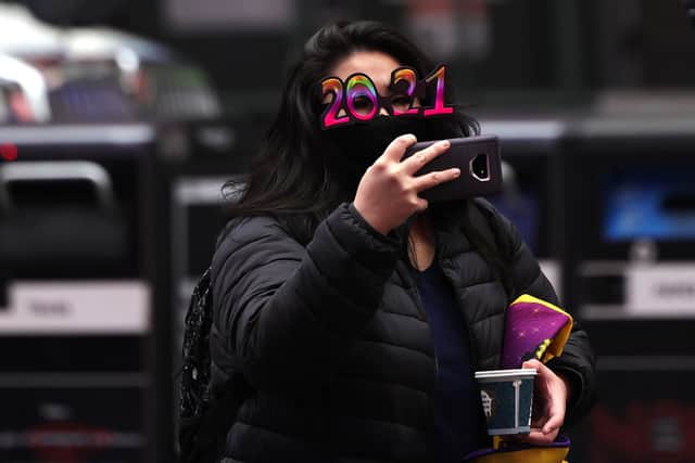 A woman in 2021 glasses takes a photo. (Photo by Michael M. Santiago/Getty Images)