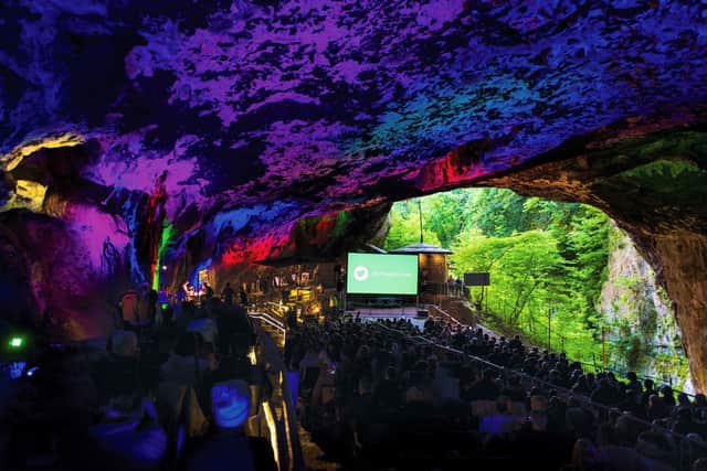The lush greenery beyond the cave mouth adds to the experience of audiences who watch films at Peak Cavern during daylight.