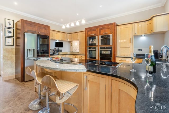 The kitchen includes a stunning island, perfect for food preparation, which doubles up as a breakfast bar. Other integrated appliances include a fridge/freezer, induction hob with extractor fan, and a coffee machine.