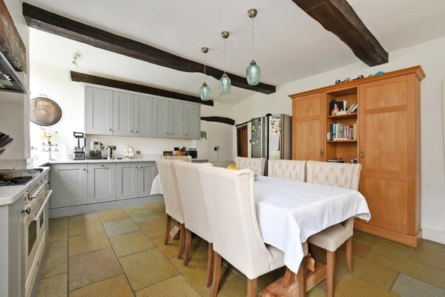 The kitchen is a blend of contemporary and traditional with fitted shaker-style storage cupboards and beamed ceiling.