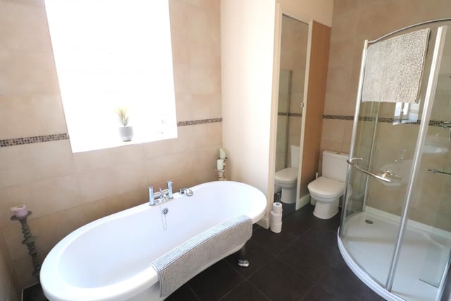 The spacious bathroom has a roll ended freestanding bath tub, separate shower cubicle, wash basin and wc.