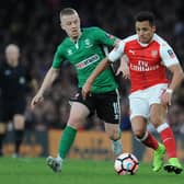 Terry Hawkridge (left) in chases Arsenal's Alexis Sanchez whilst playing for Lincoln City in an FA Cup tie.