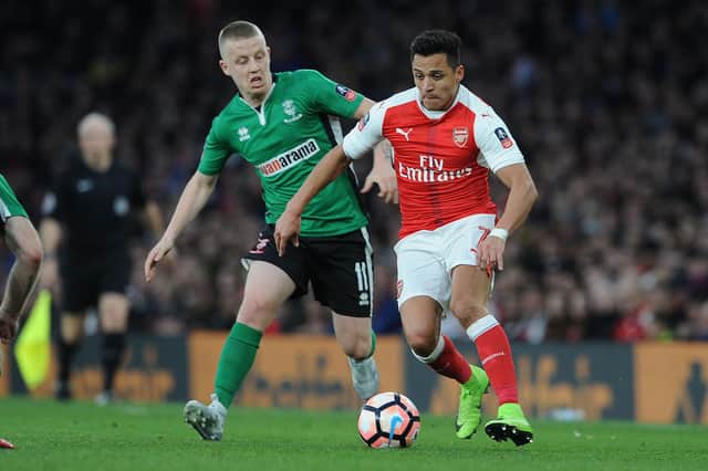 Terry Hawkridge (left) in chases Arsenal's Alexis Sanchez whilst playing for Lincoln City in an FA Cup tie.