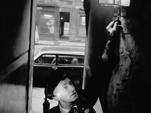 James McKay lighting a gas lamp in a tenement stair in Glasgow during the power cuts of december 1970.