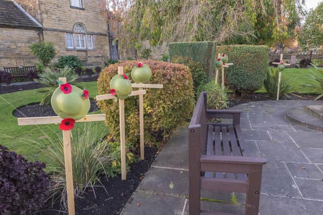 Bakewell's 2022 Remembrance display in Bath Gardens focussing on soldiers' helmets hanging from temporary grave markers. Photo by Michael Hardy