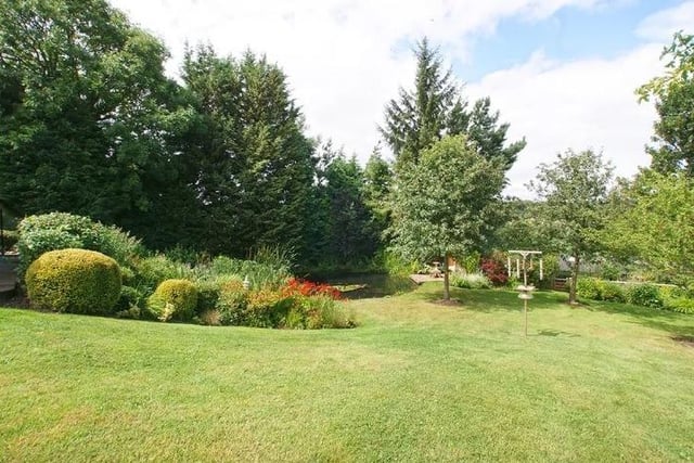 The landscaped gardens are mainly laid to lawn, interspersed with mature trees, and contain beds of flowering plants and ornamental shrubs.