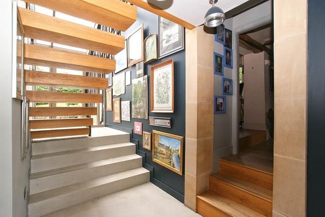 The main staircase is bathed in natural light from a large window.