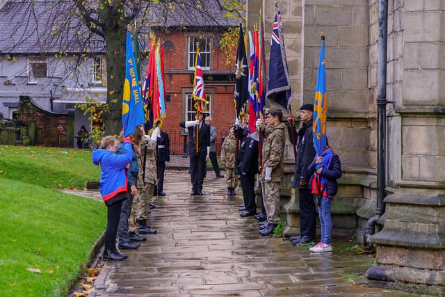 Young members of uniformed organisations proudly display their standards outside Chesterfield's parish church.