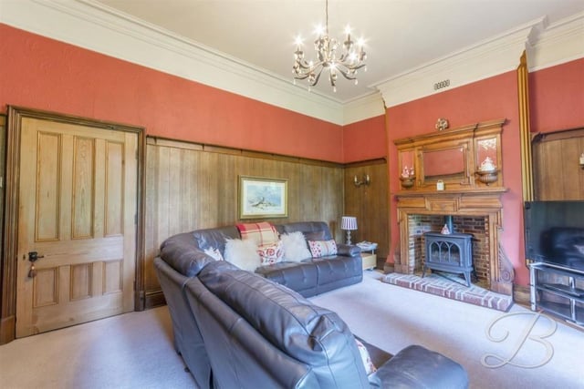 The first ground-floor reception room to inspect is this luxurious lounge, with its feature fireplace and gas stove. Wooden panelling gives the room an air of authority.
