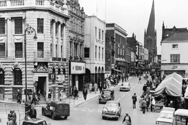 This image shows a number of shops on High Street in 1966, before it was pedestrianised