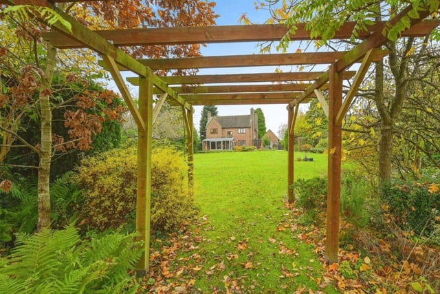 A pergola leads to further extensive gardens, and ideal location for a large garden building.