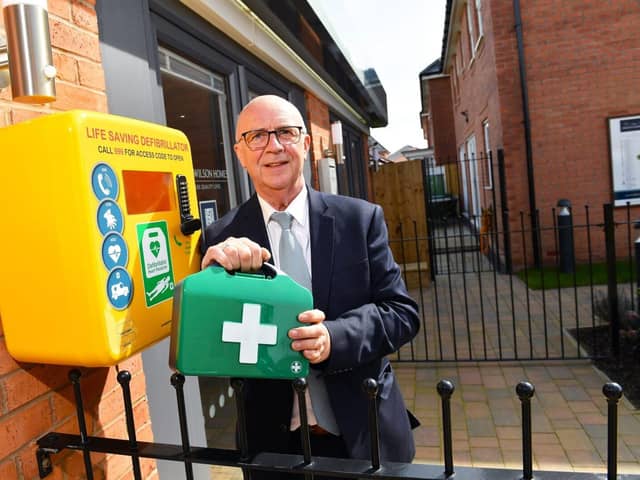 Sales Adviser, Ricky, with one of the new defibrillators installed by David Wilson Homes