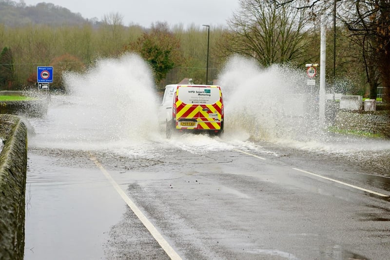 A van can be seen here trying to traverse a flooded road.
