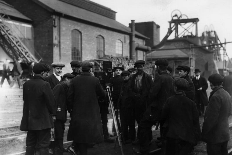 1912:  Miners in Derbyshire surrounding a cinematographer at work.  (Photo by Topical Press Agency/Getty Images)
