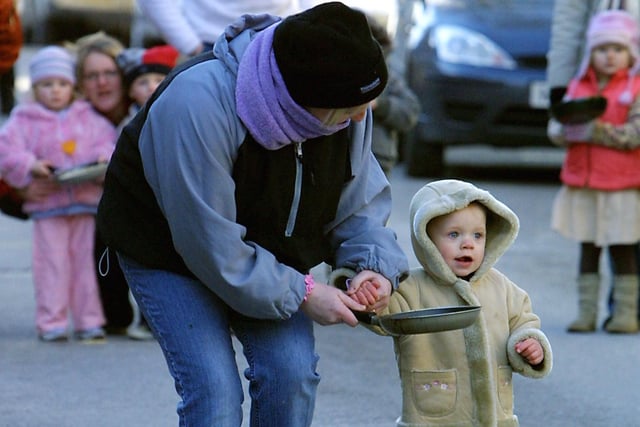 A young competitor receives help from his mother in the toddlers race at Winster Pancake Races, 2006.