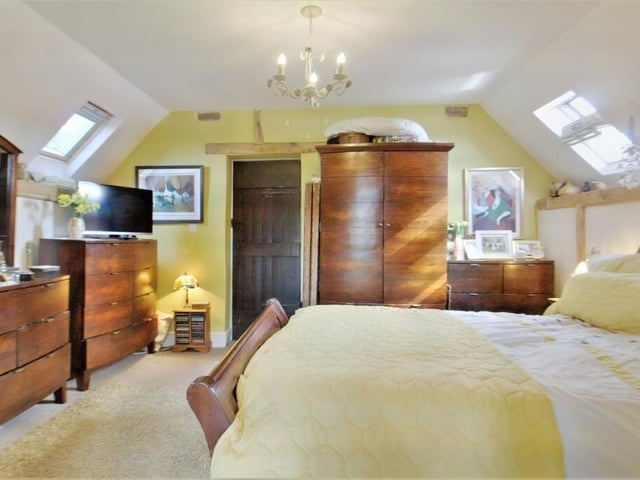 The master bedroom has exposed timberwork and offers access to the lounge/study area.