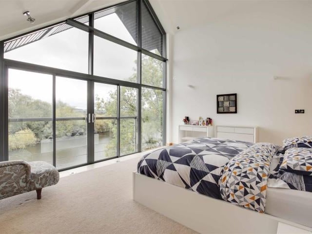 The main bedroom has carpeted flooring with underfloor heating, fitted sliding door wardrobes, wall light fixtures, access to an en-suite, full height double glazed windows and a sliding door providing access to a Juliet balcony.