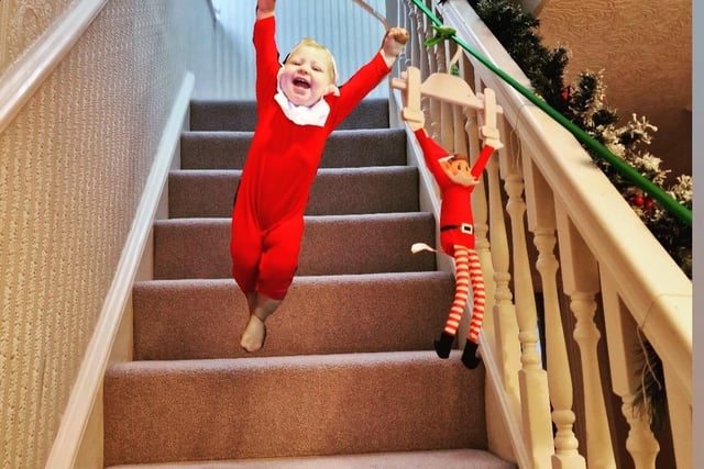 Bubbles the Elf and the traditional Elf on the Shelf ziplining down the stairs