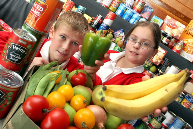 Alex Bartin, 9, and Emily Beare, 11, at Dronfield's William Levick Primary School harvest festival with food collected for local pensioners and Sheffield Cathedral breakfast project in 2006.