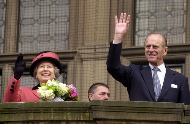 The Queen and the Duke of Edinburgh wave to crowds.