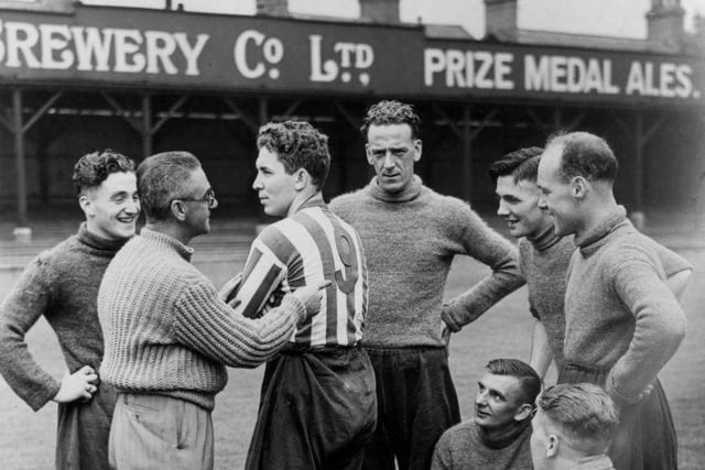 The trainer for Chesterfield Football Club, Mr Day shows off the new number on the shirt of the club's center-forward, Mr Milligan on August 11 1939: . Starting this season all player's shirts in the English League would be numbered to make it easier for spectators to recognise them. (Photo by Harry Shepherd/Fox Photos/Getty Images)